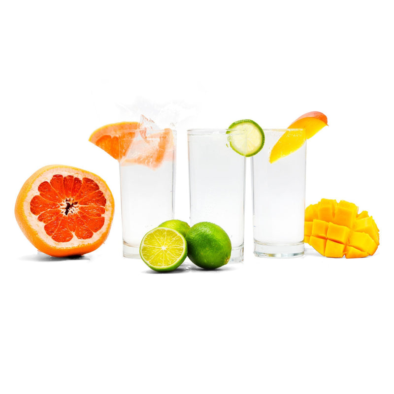 A mixed-fruit Hard Seltzer with grapefruit, lime, and mango slices next to it.