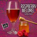 Glass of raspberry mead with honey and raspberries on a decorative background, featuring the brand 'aik'.
