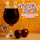 Glass of cherry hydromel mead with cherries on a honeycomb background, featuring the brand 'Cherry Bomb! Hydromel Mead'.