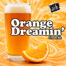 Glass of Orange Dreamin' Cream Ale with an orange slice on a swirling orange background