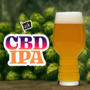 Glass of CBD IPA beer with hop cones in the background