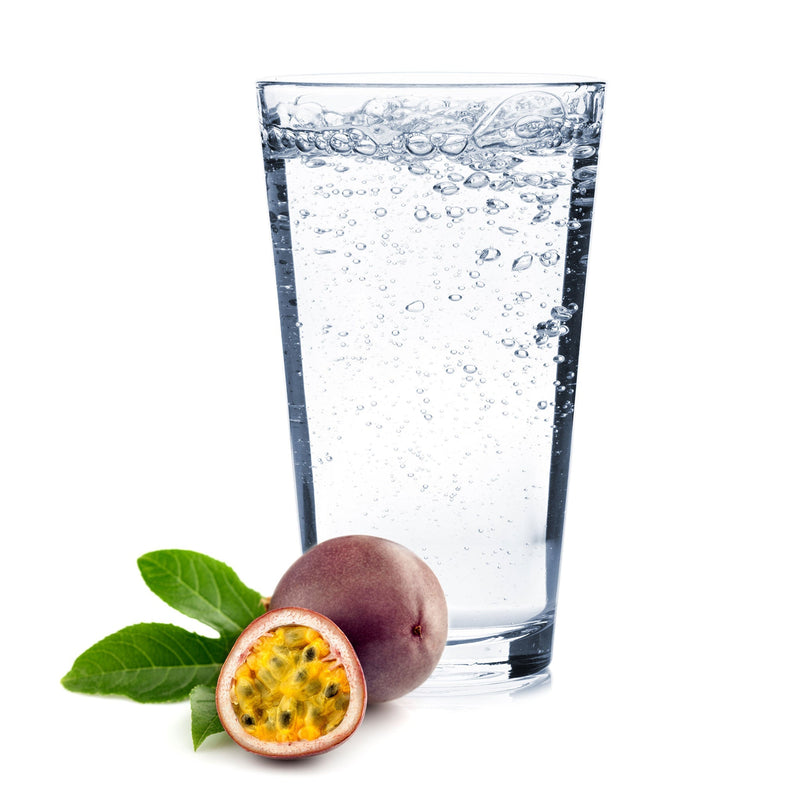 A tropical glass of Passionfruit Hard Seltzer with a halved passionfruit nearby.