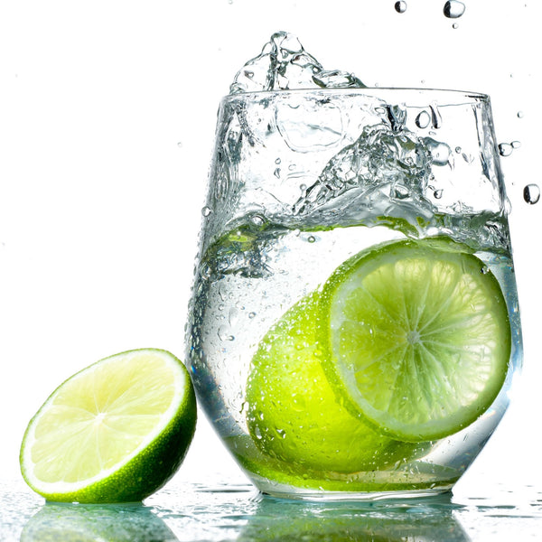 A crisp glass of Lime Hard Seltzer with fresh lime slices next to it.