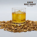 Root Shoot Malting Wheated Bourbon Whiskey in a glass with ice with oak chips around it with the Root Shoot logo in the upper right hand corn.