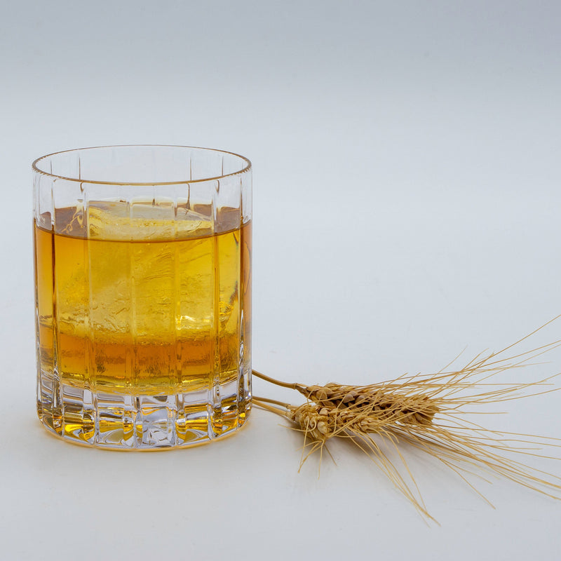 Single malt whiskey in  glass with barely next to it.